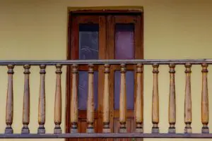 A wooden balcony railing, which is at least 36 inches high to meet building code