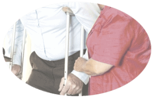 An elderly man on crutches is assisted by a health aide