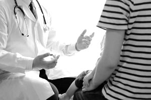A doctor explaining to a young child of similar age to the children who suffered sexual abuse at the hands of Dr. Archibald
