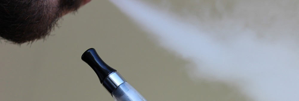 Close-up of a man holding a vape pen similar to a Juul